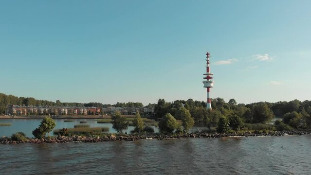 Aerial shot of a radar beacon. People usually call it a lighthouse. It is in red and white stripes. High quality 4k footage