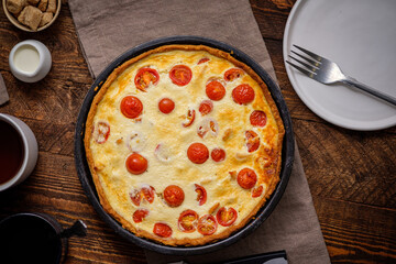 Creamy shortbread pie. Quiche with cherry tomatoes and chicken in the village on a wooden table.