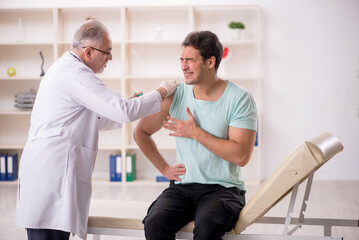 Young male patient visiting old male doctor in vaccination conce