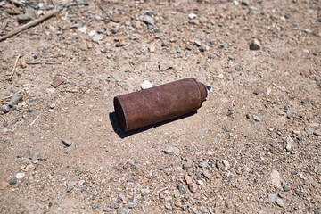 Empty and rusty spray paint can on gravel road
