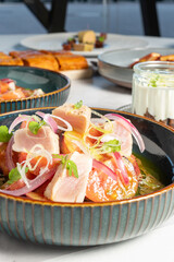 Close up of a plate of fresh tuna with vegetables, along with other seafood dishes. High quality photo