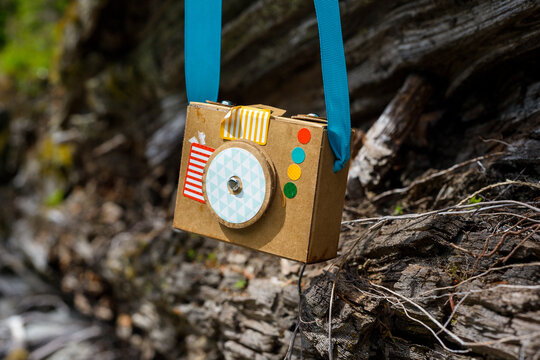 Close-up of cardboard camera hanging against wood