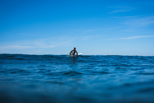 Man sitting in the Surf Lineup waiting for waves