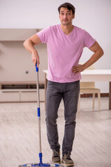 Young male contractor cleaning the house