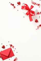 Valentine's Day vertical banner. Flat lay Valentine present, love letter and party streamers with confetti in corners on white background.