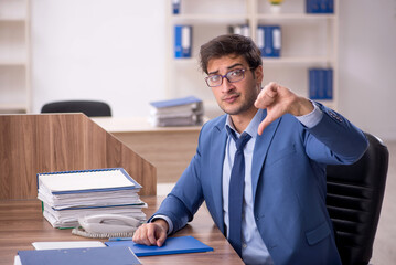 Young male employee and too much work in the office