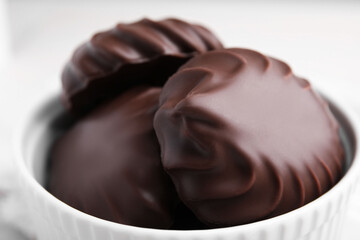 Delicious chocolate covered zephyrs in bowl, closeup