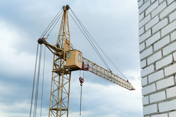 Construction site with tower crane under beautiful cloudy sky