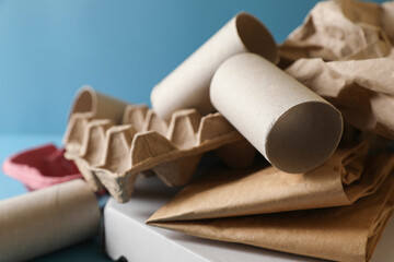 Different waste paper on light blue background, closeup
