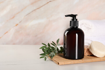 Shampoo bottle, solid shampoo bars and folded towels on white marble table, space for text