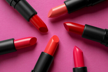 Beautiful lipsticks on pink background, flat lay