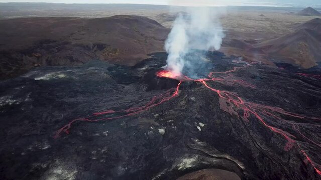 4K Aerial drone footage of Fagradalsfjall active volcano eruption in Geldingadalir, Reykjanes, Iceland. River Of Hot Lava Flowing down the hill surrounded by smoke. Iceland Volcanic eruption Grindavik