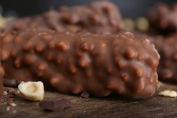 Tasty sweet chocolate bar on wooden board, closeup