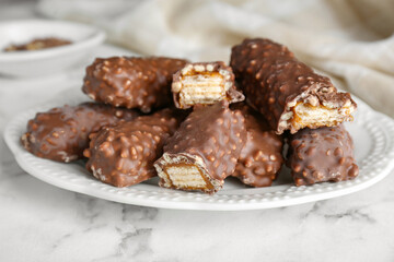 Tasty chocolate bars with caramel on white marble table, closeup