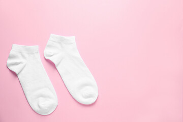Pair of white socks on pink background, flat lay. Space for text