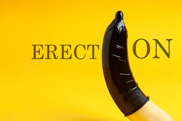 condom dressed on a banana on a yellow background, erection concept, safe sex concept, sexual male...