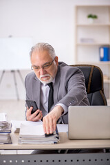 Old male employee working in the office