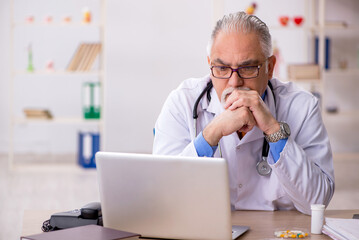 Old male doctor working in the clinic