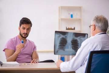 Obraz premium Young male patient visiting old male doctor radiologist