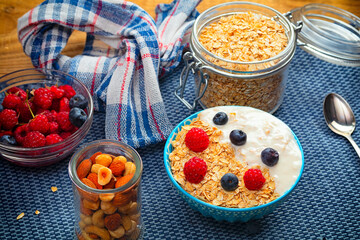 Oatmeal porridge in ceramic bowl decorated with fresh berries served with honey. Healthy breakfast concept.