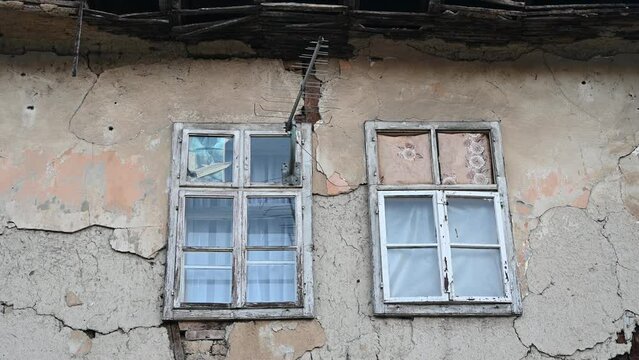 Old windows and fasade on ruined house. 