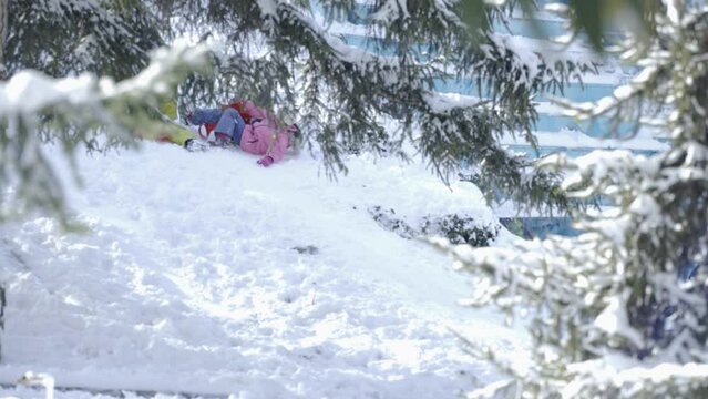 Kids sliding past in snow