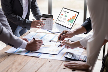 Group of confident business people point to graphs and charts to analyze market data, balance sheet, account, net profit to plan new sales strategies to increase production capacity.	 - obrazy, fototapety, plakaty