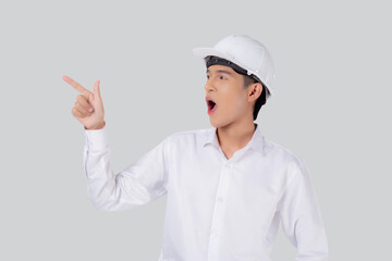 Portrait young asian man is engineer wearing helmet standing and excited isolated white background, male is architect or contractor presenting or showing something with shocked, industrial concept.