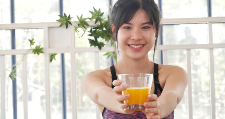 Women hands holding cold orange juice fresh fruit cool drinking. Asian women smile laugh look at camera health care home fitness lifestyle. Beautiful female pouring orange juice from cocktail bottle