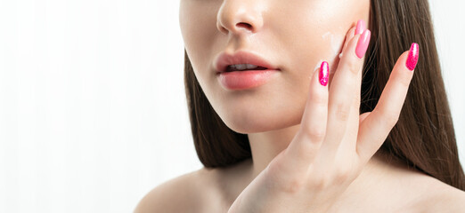 Fototapeta premium Beauty woman applying face cream on clean fresh skin, moisturize and hydrate facial with scrub, nourishing effect of mask, white background