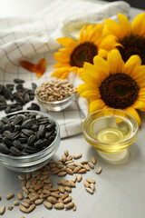 Sunflower oil and seeds on grey table, closeup