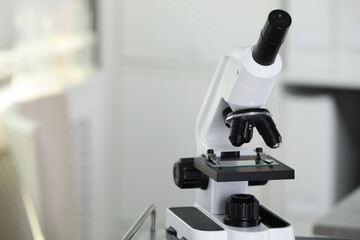 Modern medical microscope on blurred background, closeup with space for text. Laboratory equipment