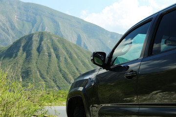 Black car near beautiful mountains and plants outdoors