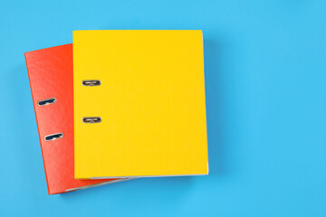 Office folders on light blue background, flat lay. Space for text