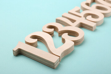 Wooden numbers on light background, closeup view