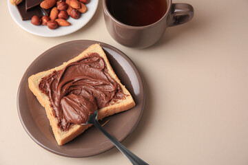 Tasty toast with chocolate paste and cup of tea served on light table, space for text