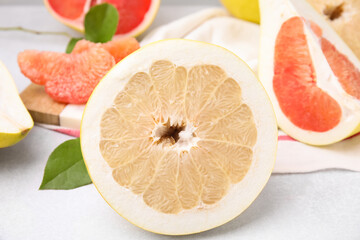 Different tasty pomelo fruits on white textured table, closeup