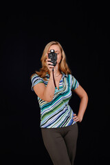 Pretty young woman hold flash meter, isolated on black background