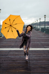 Outdoor photo of young african american woman walking on the pier.