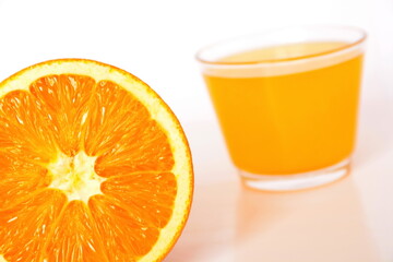 bright yellow orange pulp close up on a blurred background of a glass with natural juice. White background. Tilt horizon