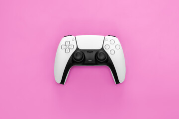 Modern white gamepad on a pink background, close up, game controller for video games, flat lay. © sav_an_dreas