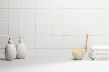 decoration in bathroom with various bath accessories and soft light on white tile wall. copy space and front view
