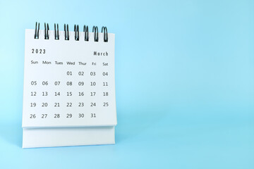 Selective focus of March 2023 desk calendar on blue background with copy space.