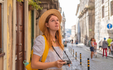 Fototapeta premium Young tourist woman enjoying a vacation in cozy old European town, summertime