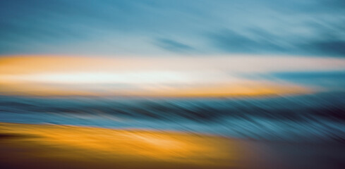 Stormy sea at sunset. Abstract motion blur seascape in bright sunset colors