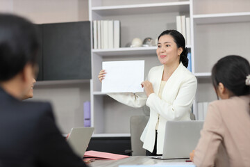 Collaborative process of professional businesspeople going over on new project, using paperwork and computer presentation with brainstorming ideas, coworker and work together at office meeting concept