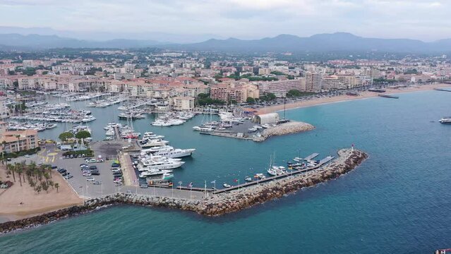 Aerial panorama of Frejus cityscape and vessels in harbor, France 