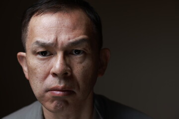 Middle-aged Japanese man in gray casual shirt on gray background. Conceptual image of world peace,...