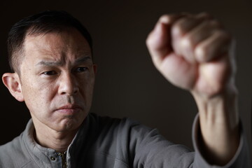 Middle-aged Japanese man in gray casual shirt on gray background. Conceptual image of world peace,...