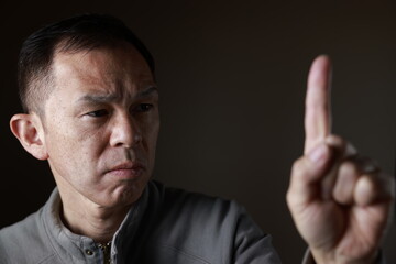 Middle-aged Japanese man in gray casual shirt on gray background. Conceptual image of world peace,...